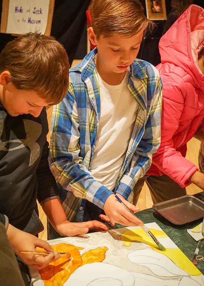 Students painting at the STEAM Fair