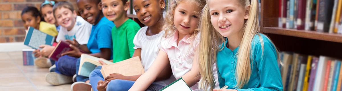 young students sitting in a row on the floor