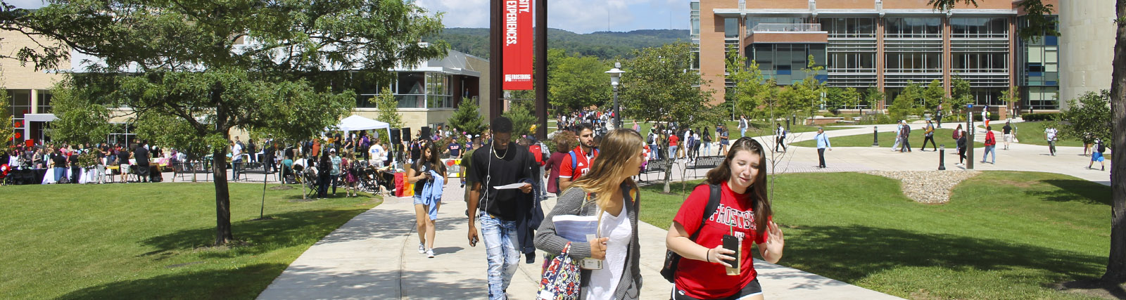 large group of students walking in quad near clocktower