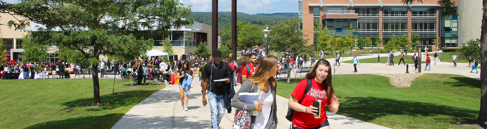 large group of students walking in quad near clocktower