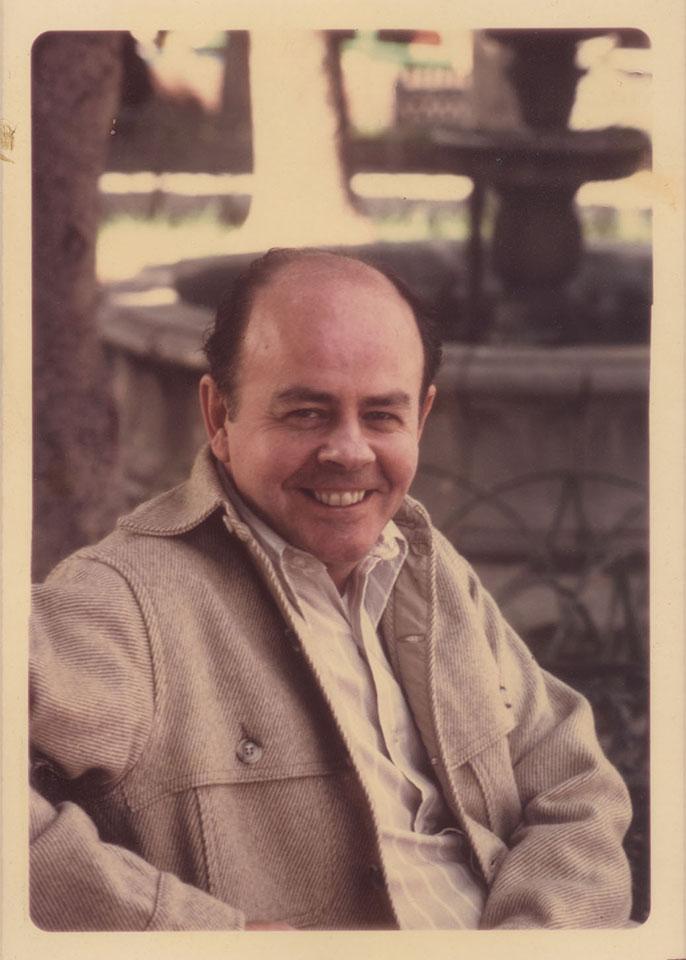 photo of middle age man sitting on a bench outoors