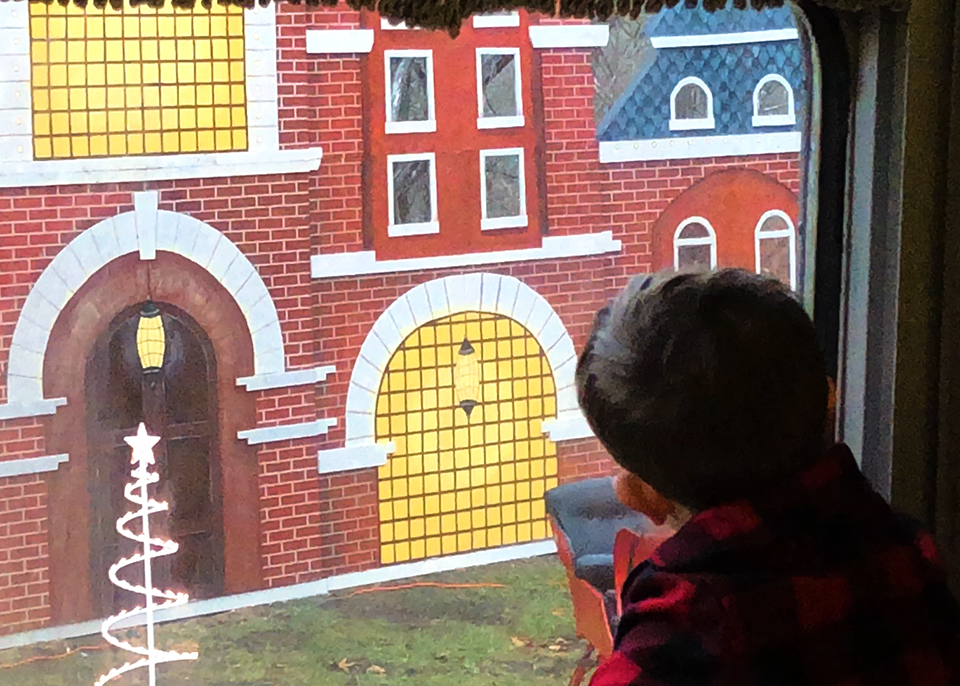 boy looks out window of train to see "Santa's North Pole castle"