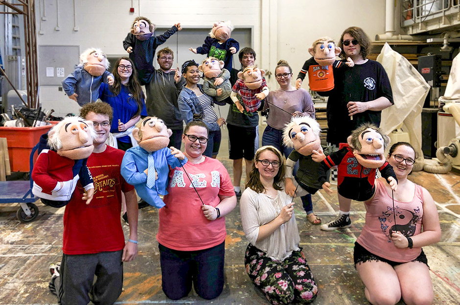 group photo of puppet class holding their puppets