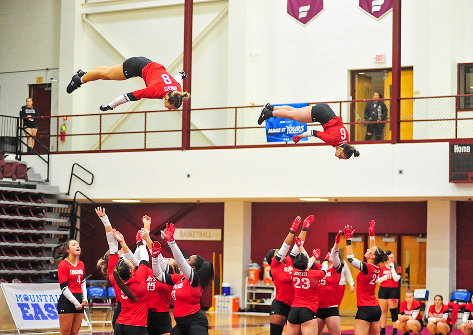tumbling team performs stunt, teammate ready to catch