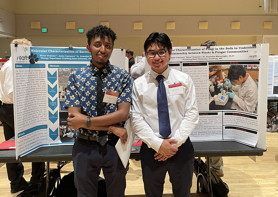 students pose with posters at undergraduate research symposium