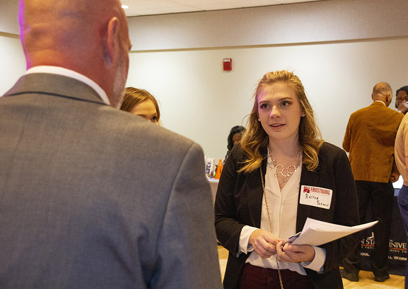 female students talks to rep durign career fair