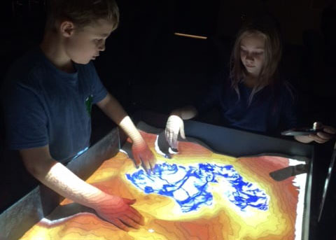 children enjoying geography table