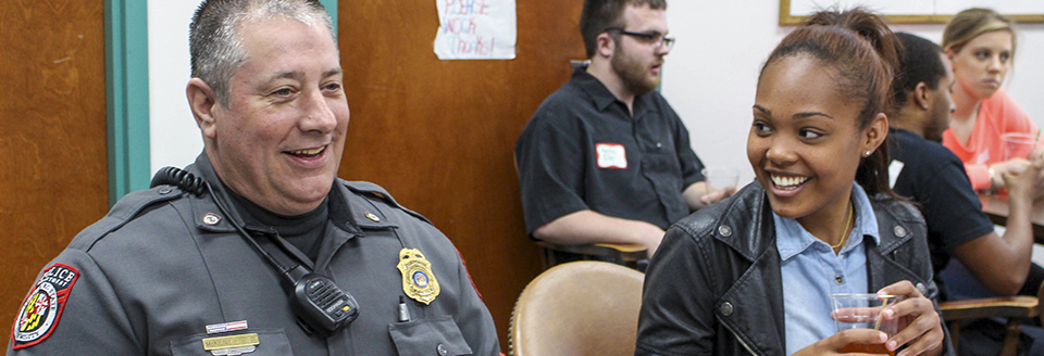 campus police officer and femal student talking at eat learn dialogue event