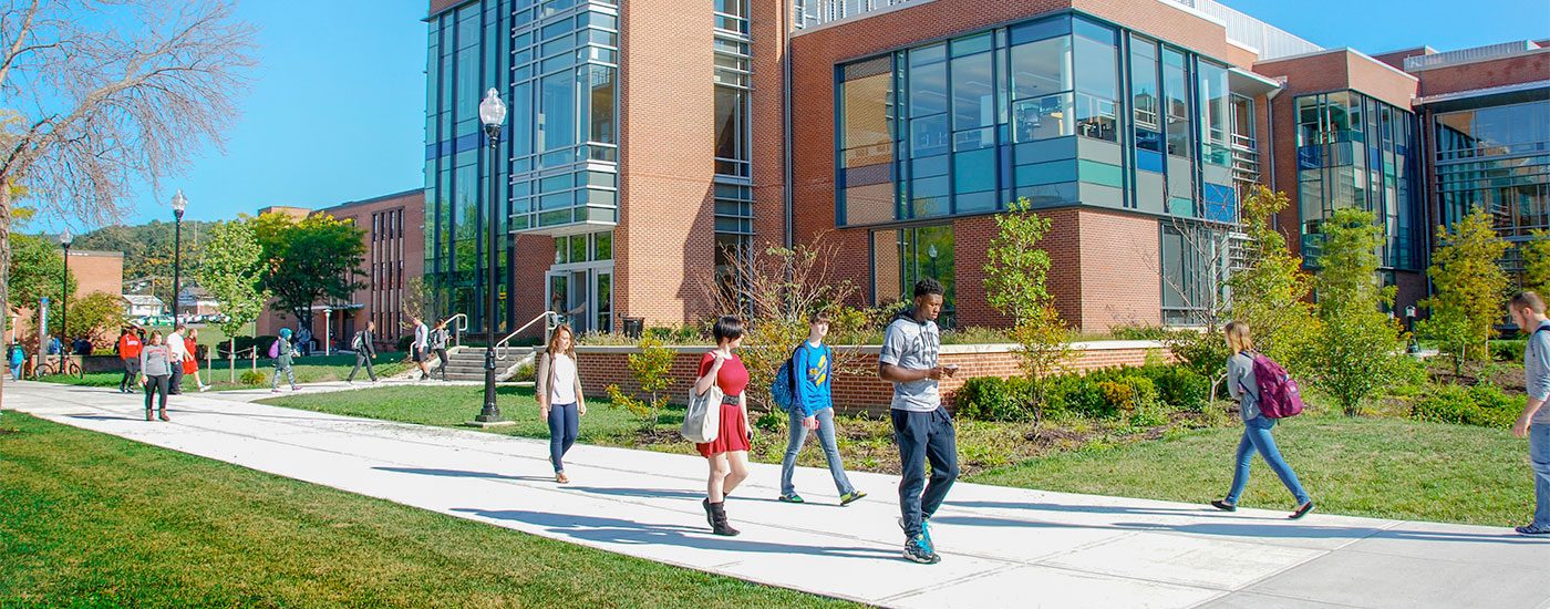 Students walk to class in front of the Gira Center for Communications Information and Technology on a bright, sunny day