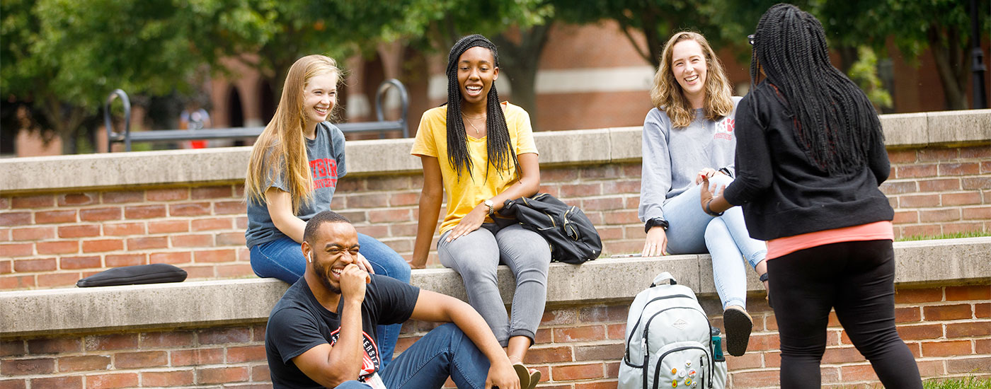 5 Frostburg State students outside laughing at something one of the others said
