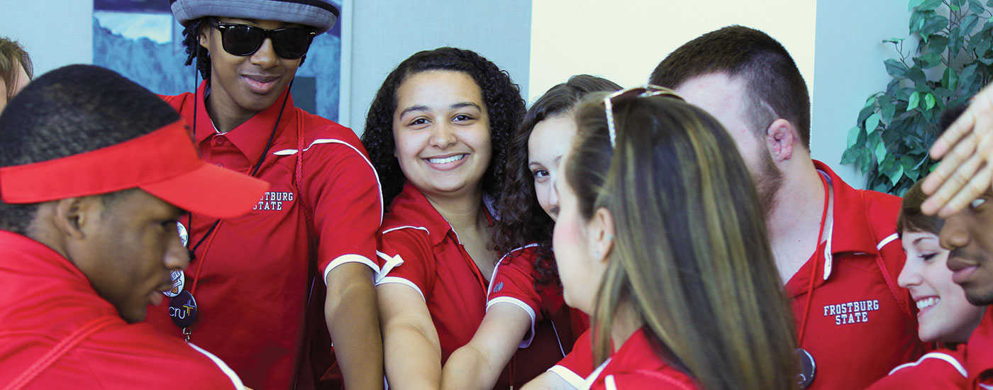 Admissions student ambassadors put their hands in together in a circle before an event