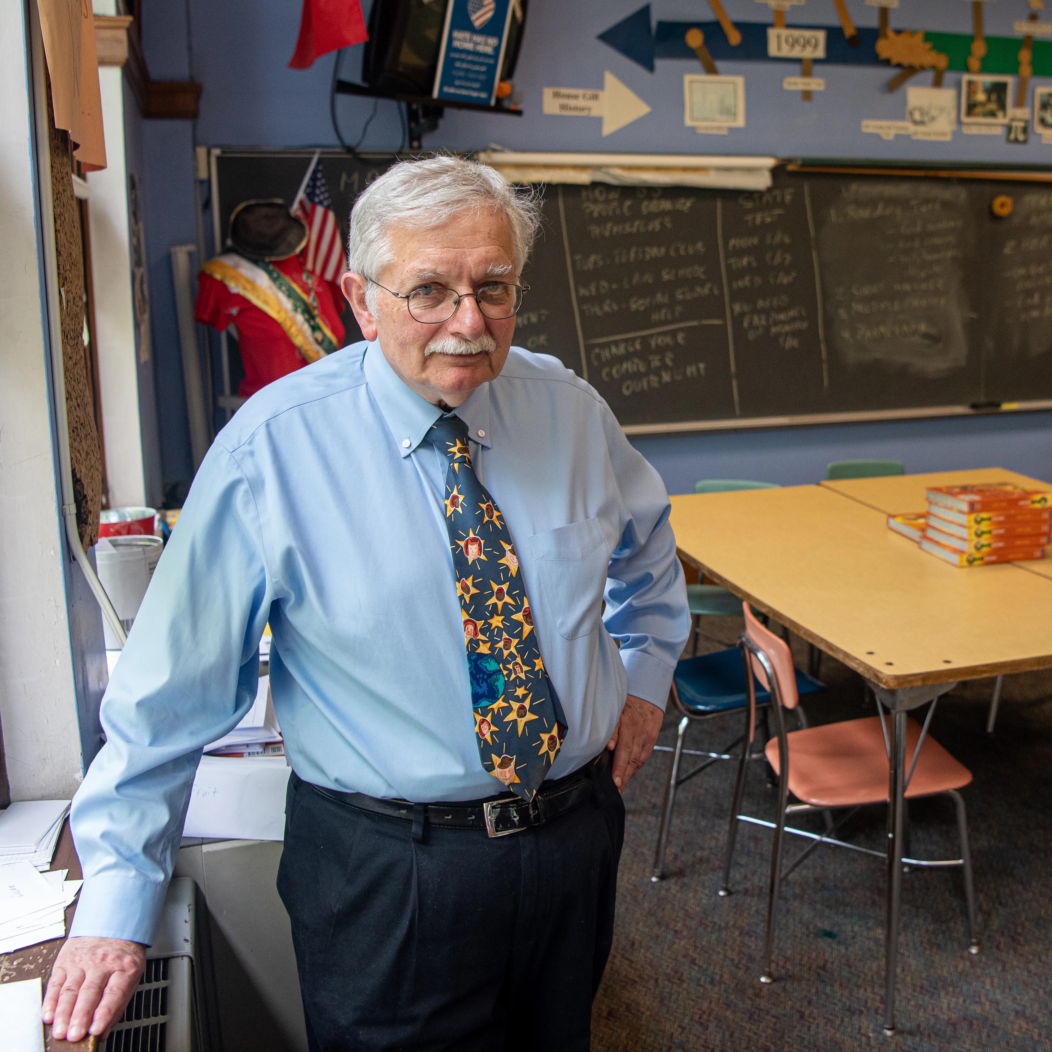 Picture of Dan Gill, author of "No More Chairs" standing in his classroom.