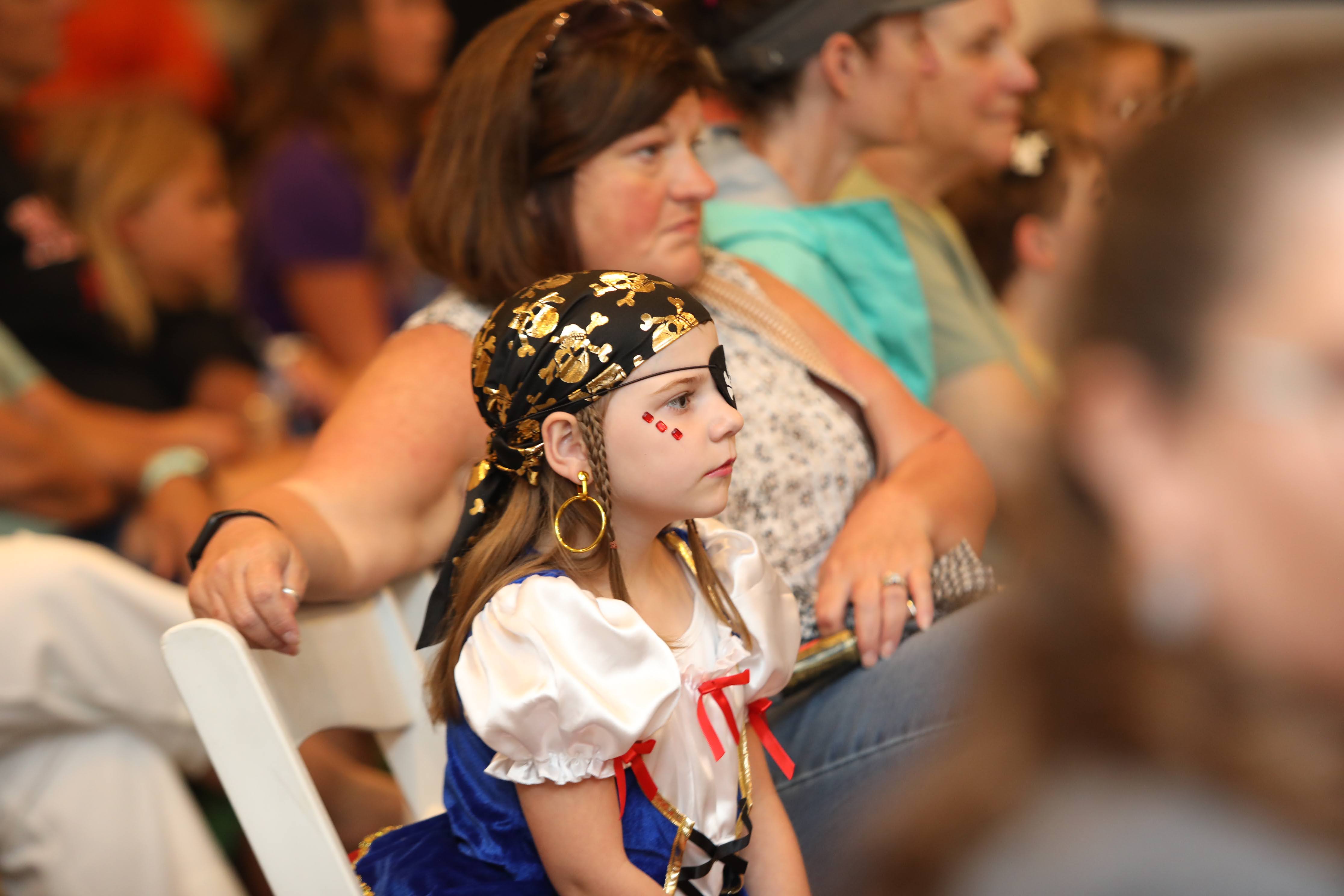 Child dressed as pirate watching presentation