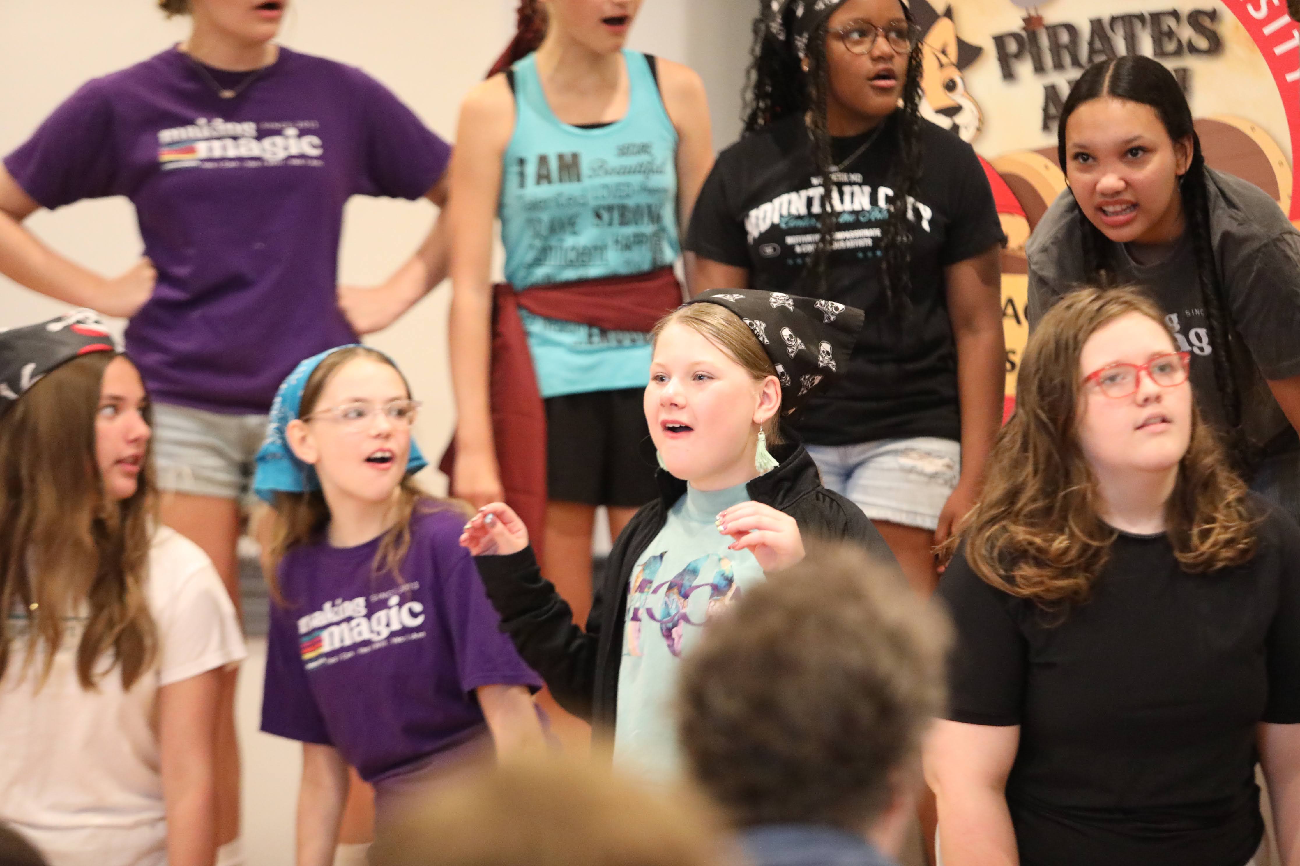 Performers on a stage singing and dancing