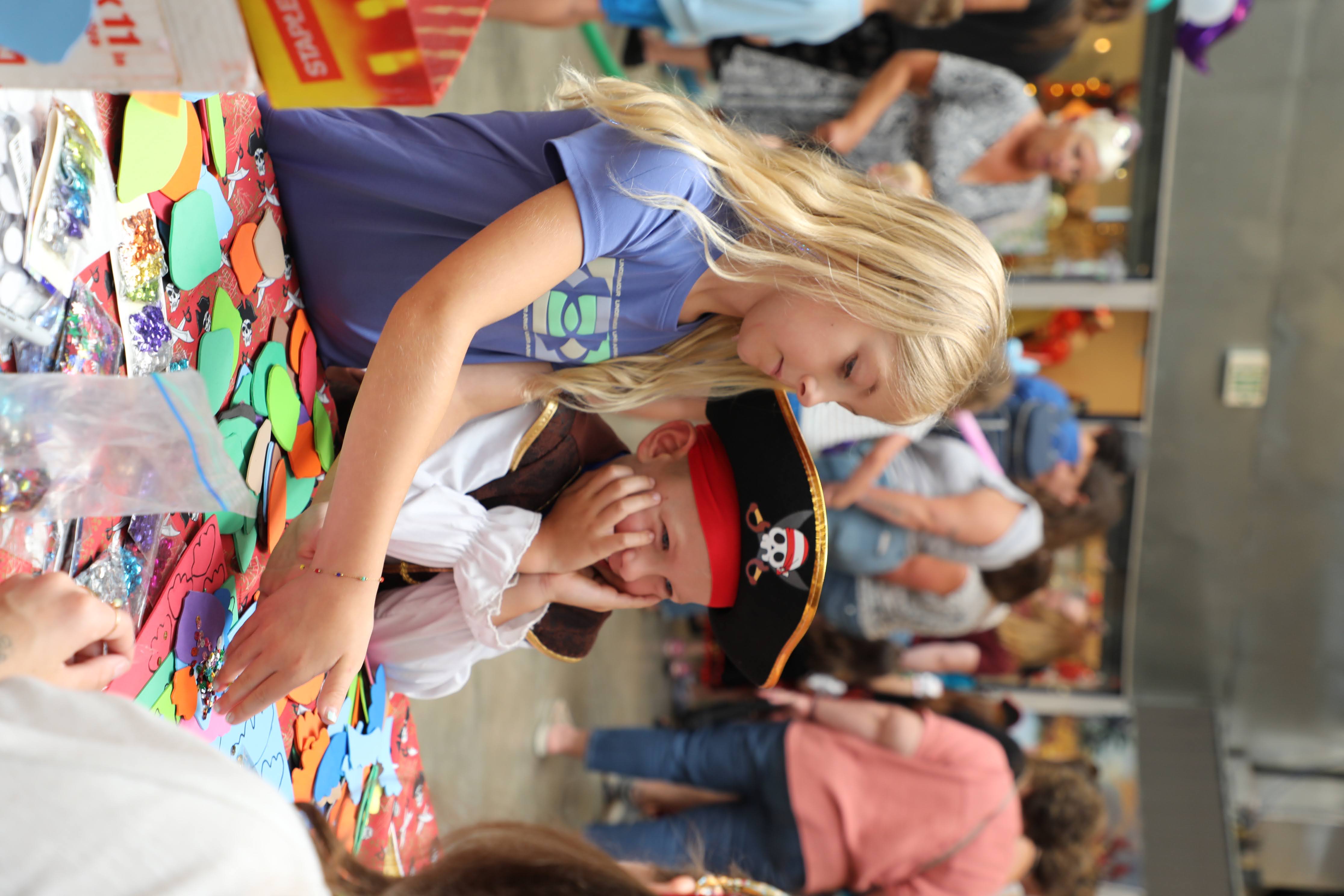 Children huddled around table dressed as pirates making a craft