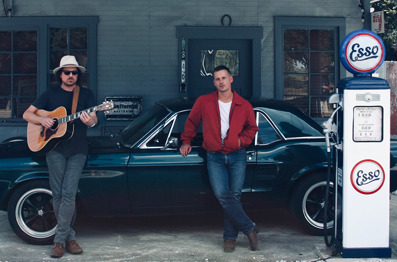 Blue Water Highway member dou lean against old muslce car at retro gas station
