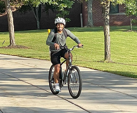 Student riding bike on campus