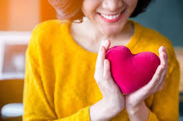 female holding cloth stuffed heart in her hands