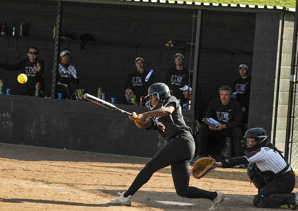 softball palyers hits ball