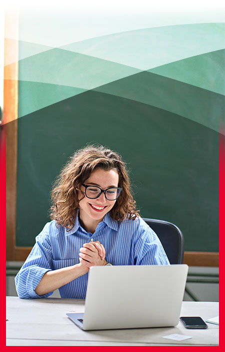 Smiling woman sitting at a computer, looking happy and engaged