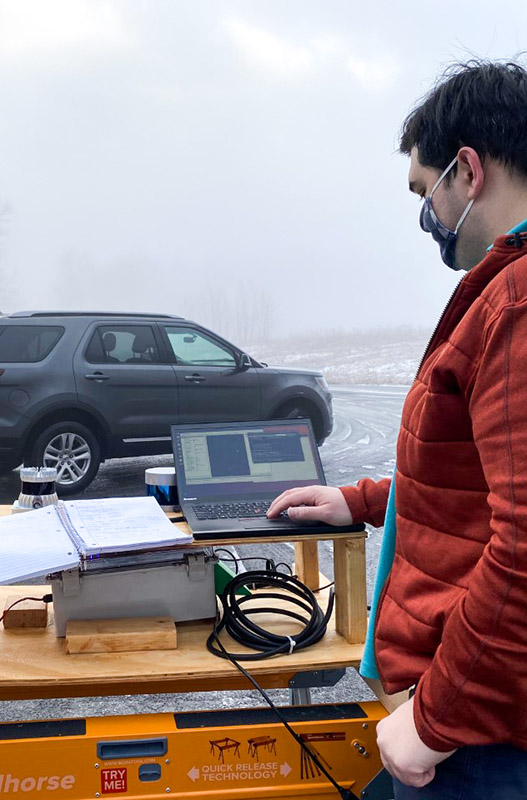 student at computer, SUV in fog