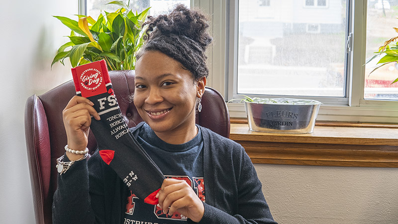 Samina Clark holds socks she designed