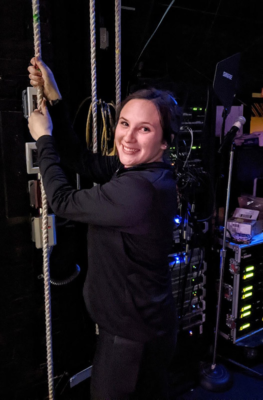 female festival goer shows pulls on stage curtain
