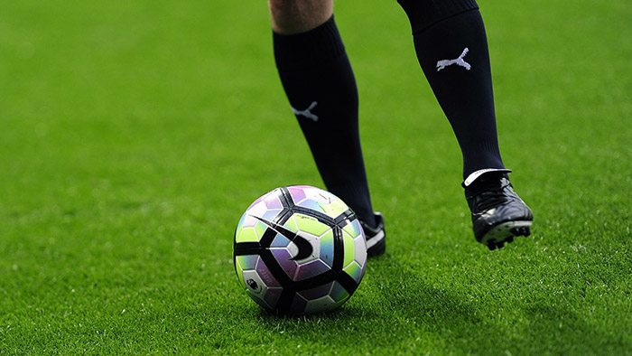 close up of legs kicking soccer ball