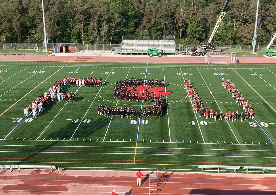 athletes spell out FSU on the football field