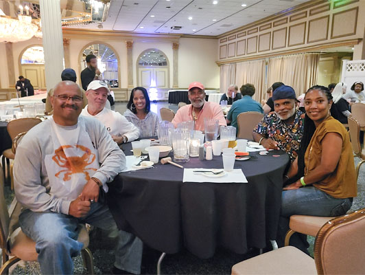 family sitting at table smiling at photographer
