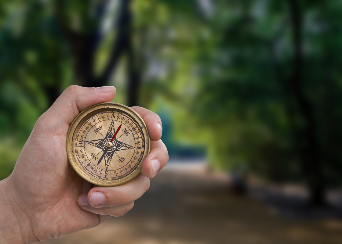 hand holding compass choosing path