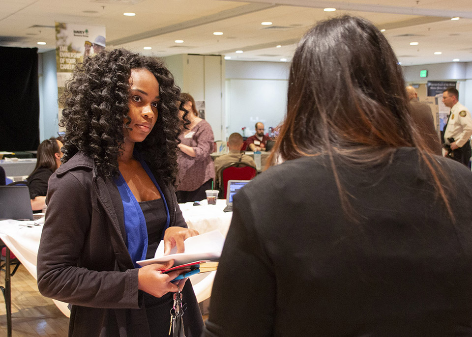 female student getting information from potential employer
