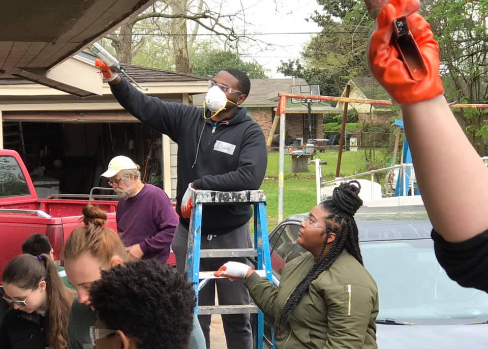 student volunteers repairing a house